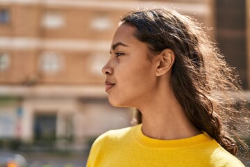 Wall Mural - Young african american woman with relaxed expression standing at street