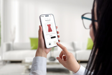 Wall Mural - concept of buying clothes online with a mobile phone. a woman uses an ecommerce website to shop conc