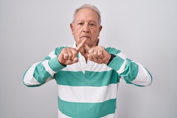 Canvas Print - Senior man with grey hair standing over white background rejection expression crossing fingers doing negative sign