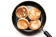 fritters in a frying pan, isolated on a white background top view