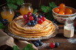 pancakes with blueberries and currants in a plate on a wooden table with currant jam