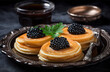 pancakes with caviar and soy sauce on a silver platter, close-up