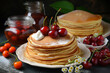 pancakes with cottage cheese and cherries sprinkled with powdered sugar on the table