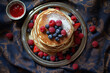 A stack of pancakes with fresh blueberries and raspberries and powdered sugar. View from the top