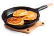 pancakes on a hot frying pan isolated on a white background