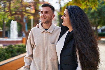 Poster - Man and woman couple hugging each other standing at park