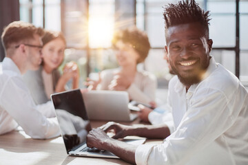 Portrait of smiling African American business man with executives working in background