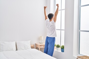 Sticker - Young arab man waking up stretching arms at bedroom