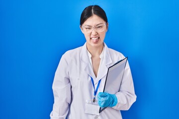 Sticker - Chinese young woman working at scientist laboratory sticking tongue out happy with funny expression. emotion concept.