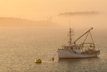 Hazy Foggy Sunset Off The Coast Of Canada With A Fishing Boat Anchored