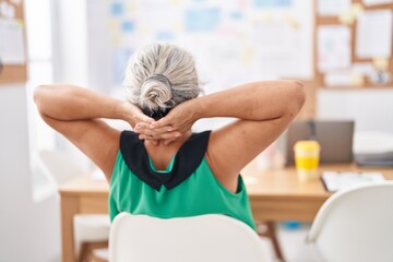 Sticker - Middle age grey-haired woman business worker relaxed with hands on head at office