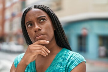 Wall Mural - African american woman standing with doubt expression at street