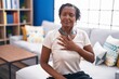 © Krakenimages.com - Middle age african american woman sitting on sofa suffering heart attack at home