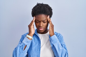 Wall Mural - African american woman standing over blue background with hand on head, headache because stress. suffering migraine.