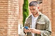 © Krakenimages.com - Young hispanic man smiling confident using smartphone at street