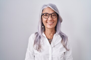 Poster - Middle age woman with tattoos wearing glasses standing over white background with a happy and cool smile on face. lucky person.