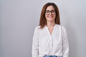 Wall Mural - Brunette woman standing over white isolated background with a happy and cool smile on face. lucky person.