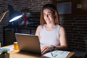 Wall Mural - Brunette woman working at the office at night with a happy and cool smile on face. lucky person.