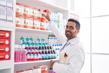 Sticker - Young hispanic man pharmacist organizing shelving at pharmacy