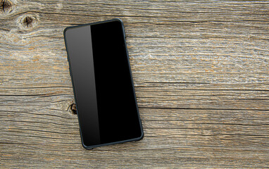 Black smartphone on a wooden table.