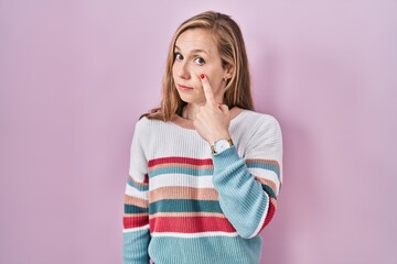 Sticker - Young blonde woman standing over pink background pointing to the eye watching you gesture, suspicious expression