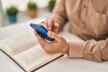 Sticker - Senior man reading book using smartphone at home