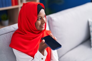 Sticker - Young beautiful woman talking on smartphone sitting on sofa at home