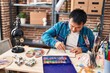 © Krakenimages.com - Young chinese man artist drawing on notebook at art studio