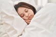 © Krakenimages.com - Young woman with down syndrome lying on bed sleeping at bedroom