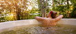 woman with flower in hair relaxing in outdoor hot tub in forest. nature spa treatment. banner with copy space