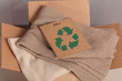 Cardboard box with used wardrobe for reuse and card with circular economy logo. Reusing, recycling materials, reducing waste in fashion, second hand apparel idea. Circular fashion, zero waste concept