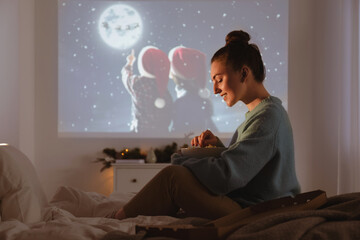 Sticker - Woman with popcorn watching Christmas movie via video projector at home