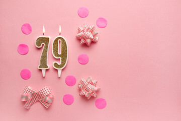 Number 79 on pastel pink background with festive decor. Happy birthday candles. The concept of celebrating a birthday, anniversary, important date, holiday. Copy space. banner