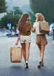 © Mikolette Moller/peopleimages.com - Shopping bag, friends and back of women walking for happy travel on urban city street after buying retail fashion. Sales deal, gift and rich female customer on road outdoor with present