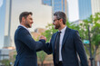 © Volodymyr - The two business team worked together to achieve their goals. Business man shaking hands. Two businessmen handshake outdoor. Handshake business people.