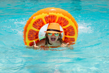 Wall Mural - Summer fun kids face. Kid swim with floating ring in swimming pool. Kids summer vacation. Happy child boy with inflatable ring in poolside.