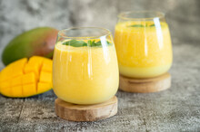 Fresh Mango Lassi In Glasses On Grey Background With Copy Space.