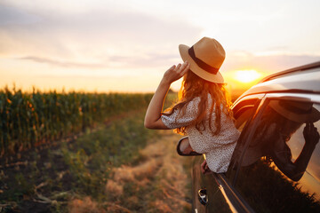 Wall Mural - Towards adventure! Happy woman is enjoying the trip in the car. Lifestyle, travel, tourism, nature, active life.