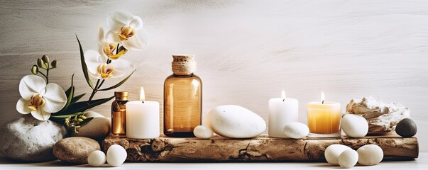 Beauty treatment items for spa procedures on white wooden table and marble wall. massage stones, essential oils and sea salt. candle, rolled up white towel, plants, copy space