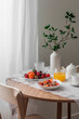 Cozy breakfast served - porridge oatmeal with seasonal fruits and berries, orange juice, tea on a wooden round table