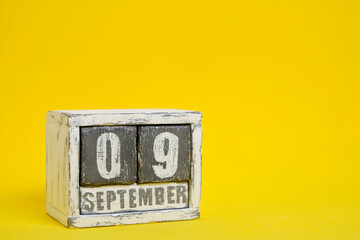 September 09 wooden calendar standing yellow background with an empty space for text.