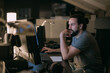© Anna - A young man works in the office in front of monitors in the evening.