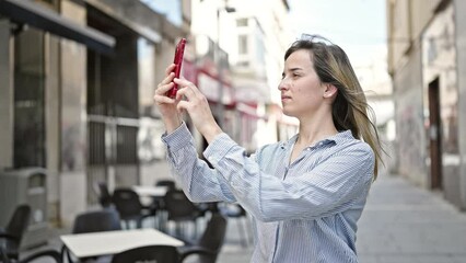 Poster - Young blonde woman smiling confident make photo by smartphone at coffee shop terrace