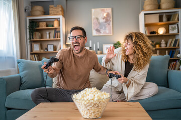 couple man and woman husband wife play console video games at home