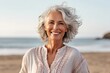 © igolaizola - woman in his 60s that is wearing a casual summer dress against a sunny beach background