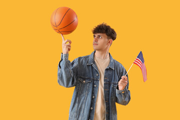 Wall Mural - Young man with USA flag and ball on yellow background