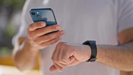 Sticker - Young latin man using smartphone and smartwatch at park