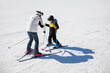 © Blue Jean Images - Little boy learning how to ski with his coach