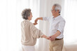 © Blue Jean Images - Cheerful senior couple dancing at home