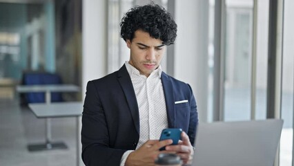 Sticker - Young latin man business worker using laptop and smartphone with winner gesture at office